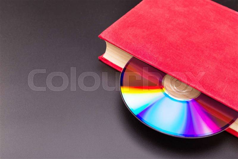 Disk sticks out from red book, stock photo
