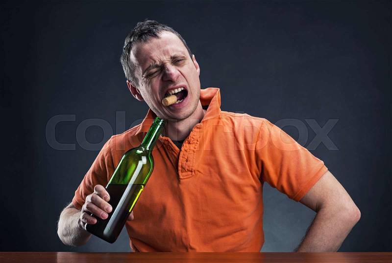 Alcoholic is opening a bottle of wine , stock photo