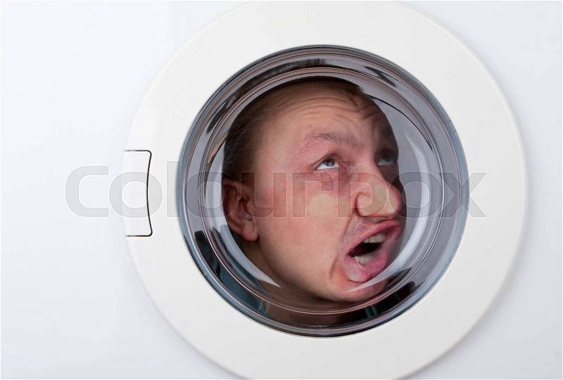 Close-up of bizarre man inside washing machine, stock photo
