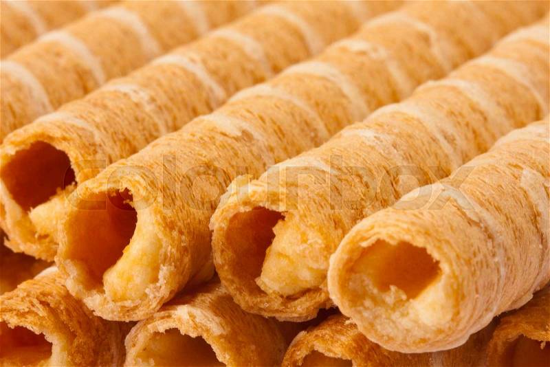 Close-up of striped wafer rolls filled with cream, stock photo