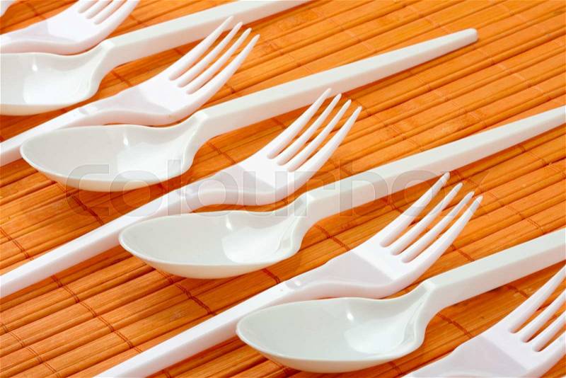 A row of plastic silverware. Spoons and forks, stock photo