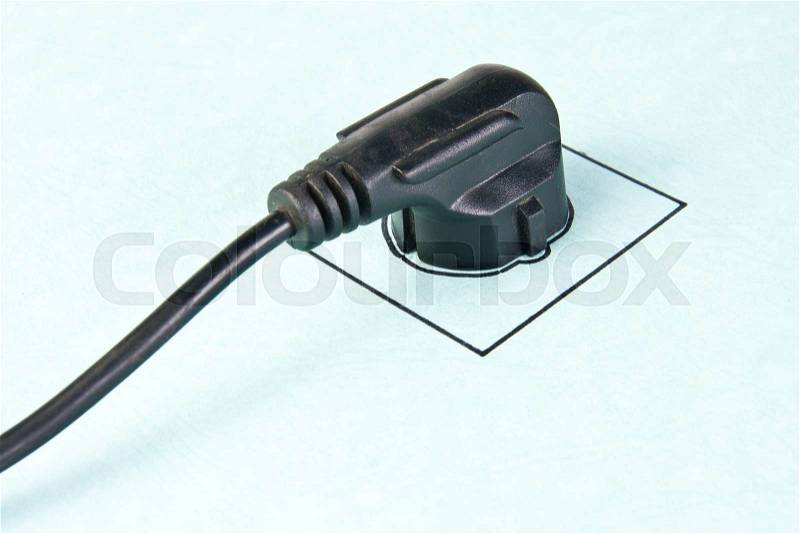 Electrical plug in drawn socket on the wall, stock photo