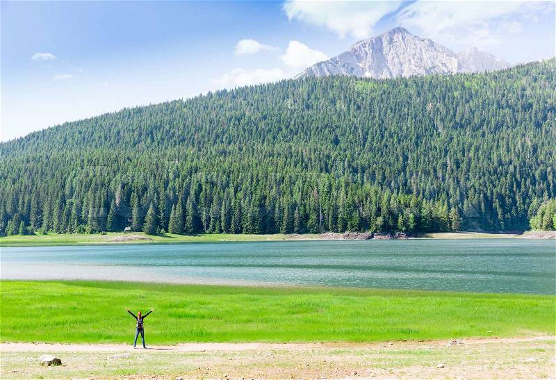 Happy traveler at lake in mountains, Durmitor National Park, Montenegro, stock photo