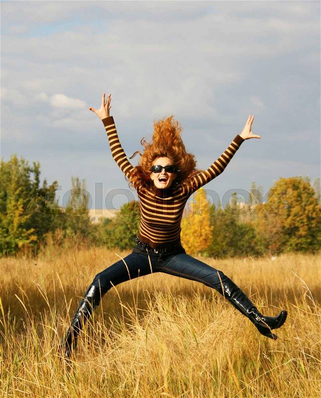Jumping young woman in autumn park, stock photo