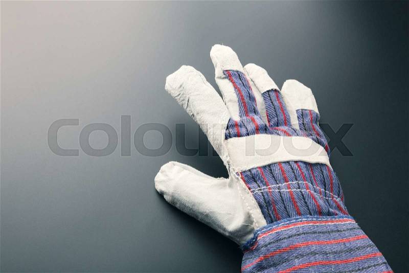 Work glove against grey background, stock photo