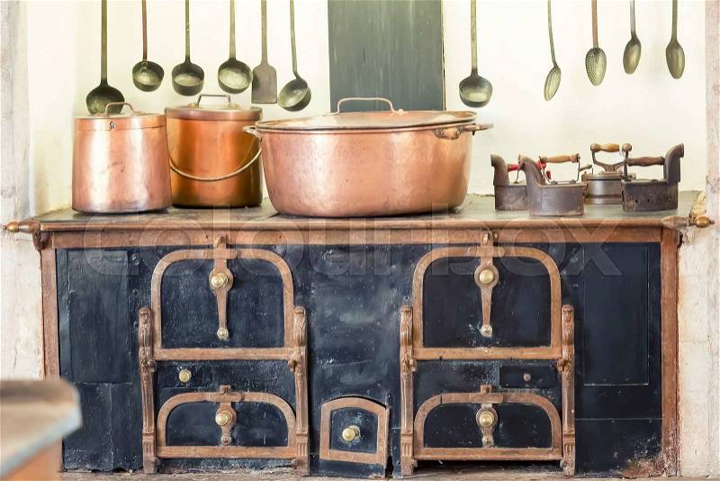 Retro kitchen interior with old pans, pot on the furnace , stock photo
