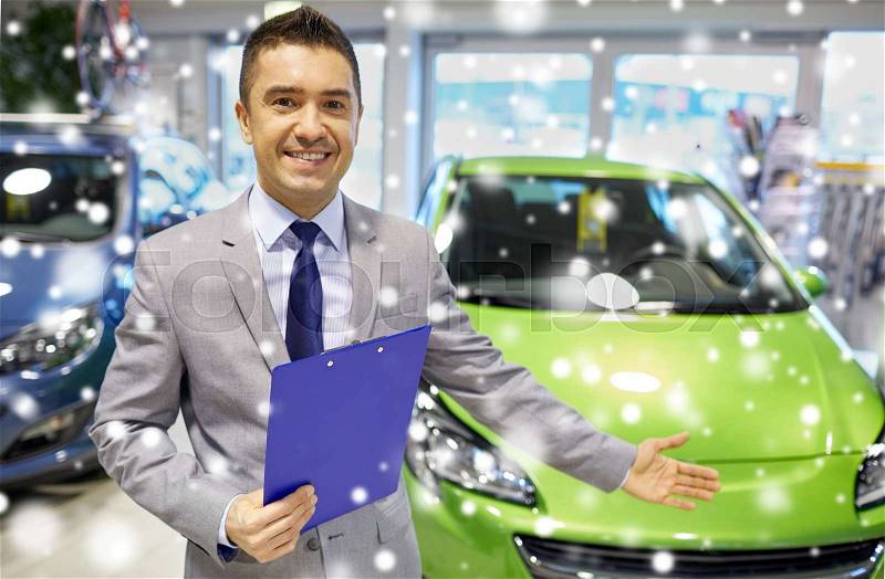 Auto business, car sale, consumerism and people concept - happy man at auto show or salon over snow effect, stock photo