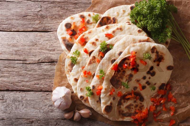 Indian Naan flat bread with garlic and herbs on the table. horizontal view from above , stock photo
