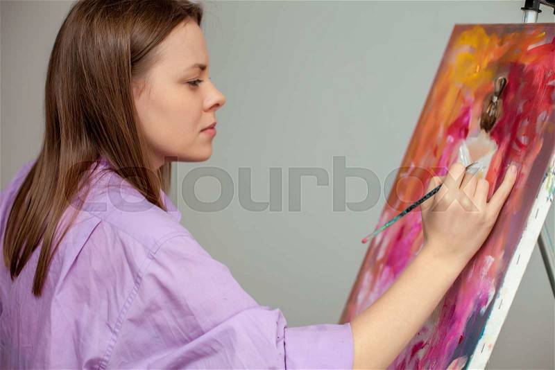Creative female artist drawing the picture in the studio, stock photo