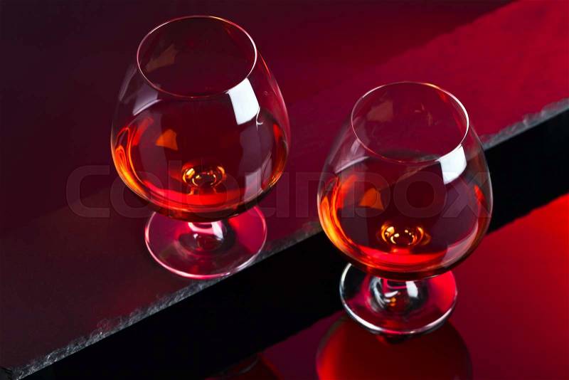 Snifter with brandy on a red background, stock photo