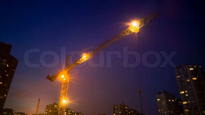 High building crane working at night, stock photo