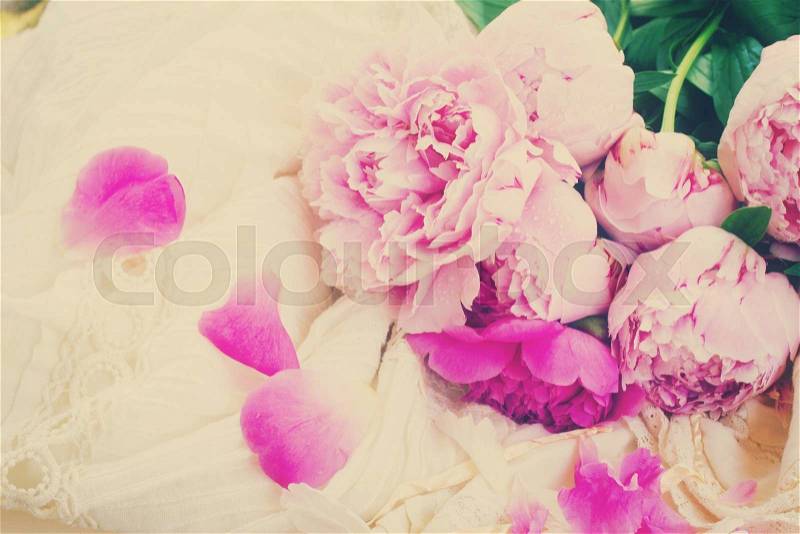 Pink fresh peonies and white wedding dress, retro vintage toned, stock photo