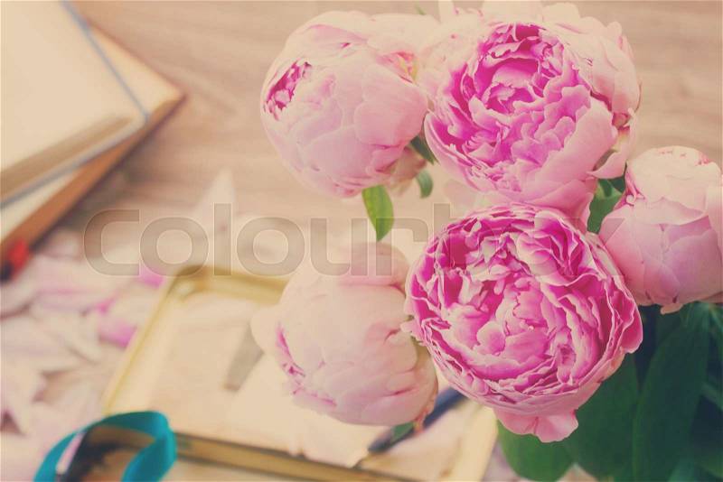 Bouquet of pink peonies in vase on wooden table, retro toned, stock photo