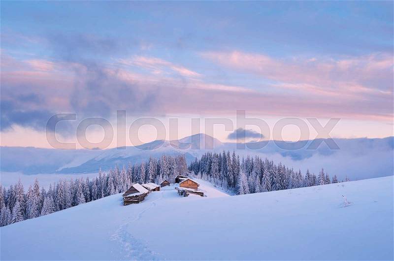 Winter landscape in the mountains. Sky with clouds at dawn. Mountain village with wooden houses of shepherds. Carpathians. Ukraine, Europe, stock photo