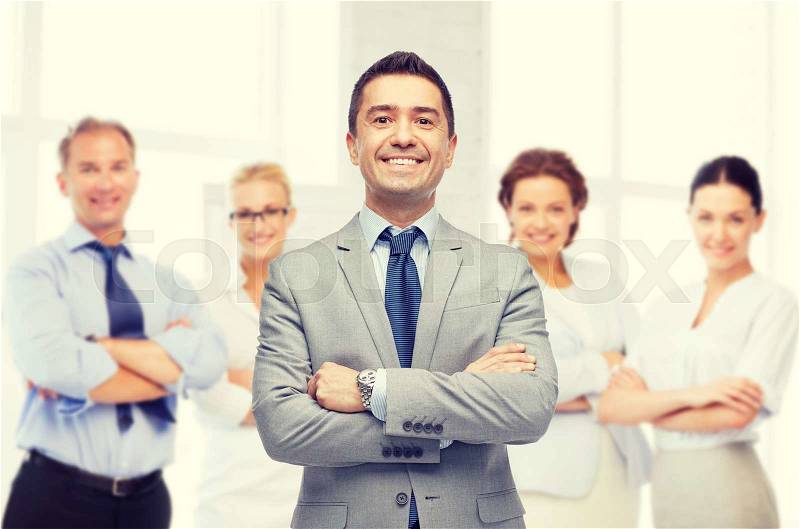 Business, people and office concept - happy smiling business team over office room background, stock photo