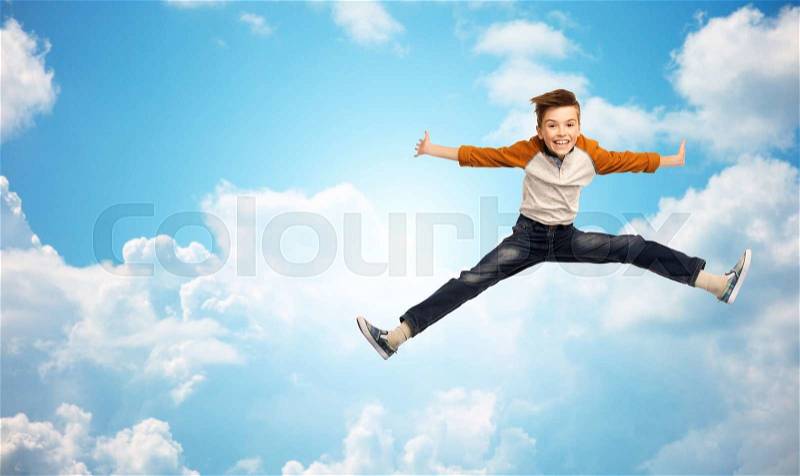Happiness, childhood, freedom, movement and people concept - happy smiling boy jumping in air over blue sky and clouds background, stock photo