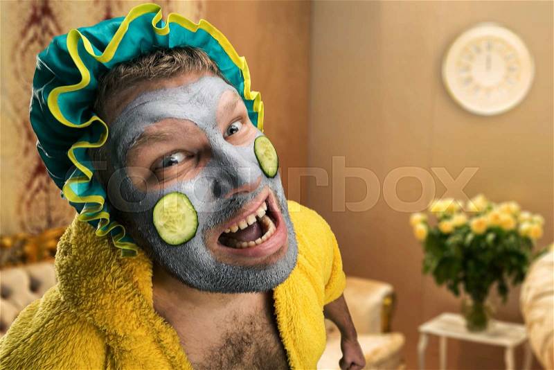 Strange, crazy man with face pack in home interior, stock photo