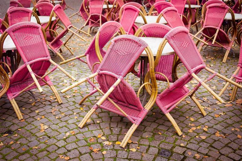 Closed outdoor cafe terrace with pink chairs, stock photo