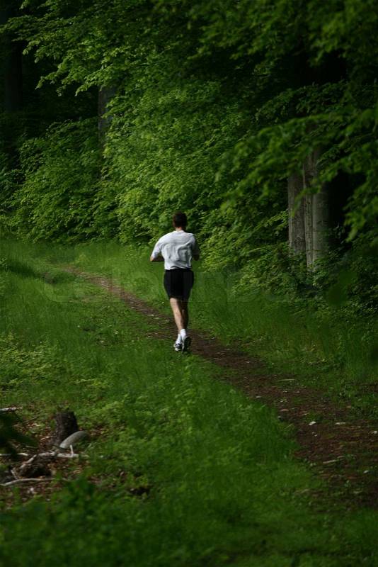 Man running jogging on a forest path, stock photo