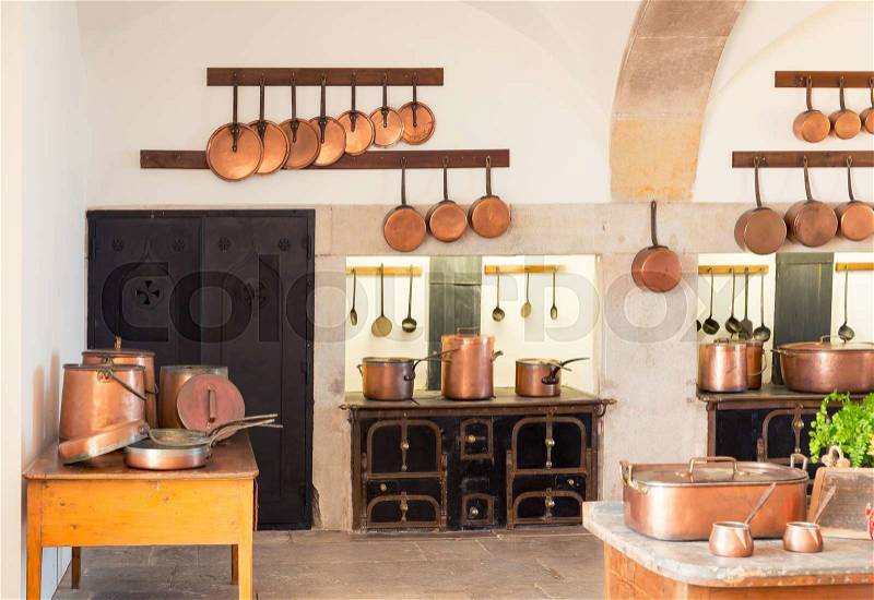 Retro kitchen interior with old brass pots and cupboard, stock photo
