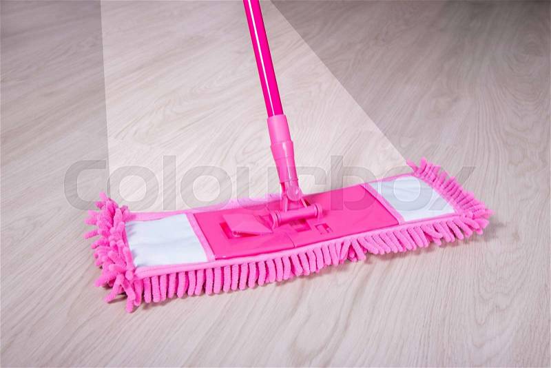 Close up of wooden floor with pink mop - before and after concept, stock photo