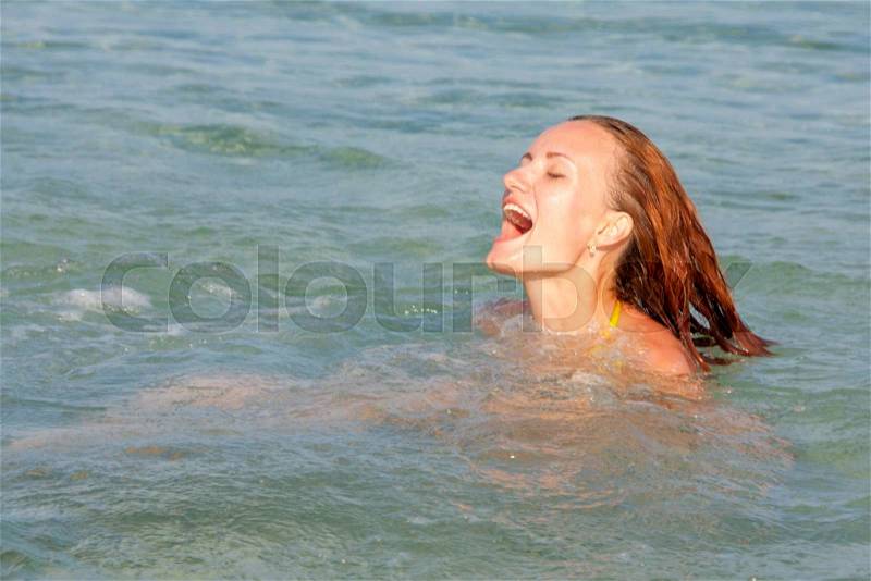 Happy swimming woman in the sea, stock photo