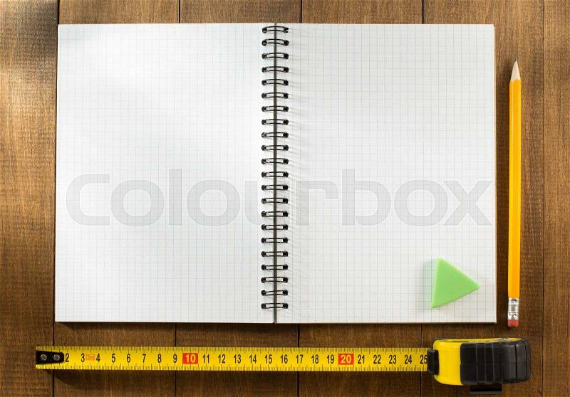 Tape measure and pencil on wooden texture, stock photo