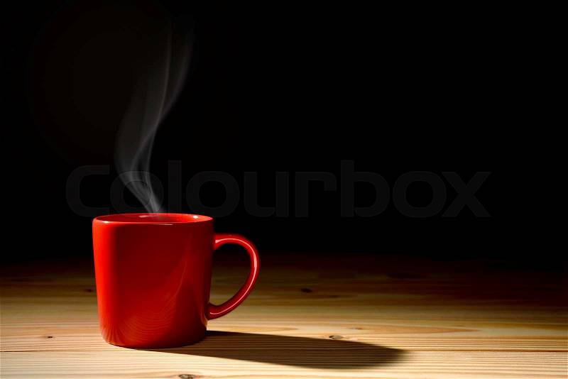 Cup of coffee with smoke on old wooden background, stock photo
