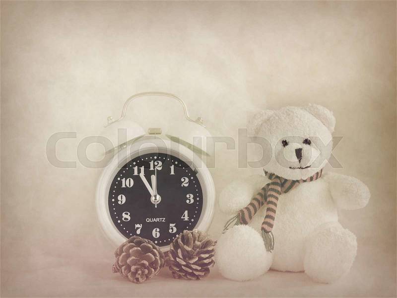 Alarm clock and white teddy bear and pinecones , vintage style for background, stock photo