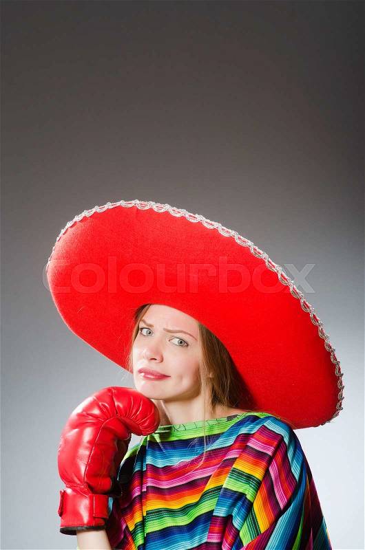 The girl in mexican vivid poncho and box gloves against gray, stock photo