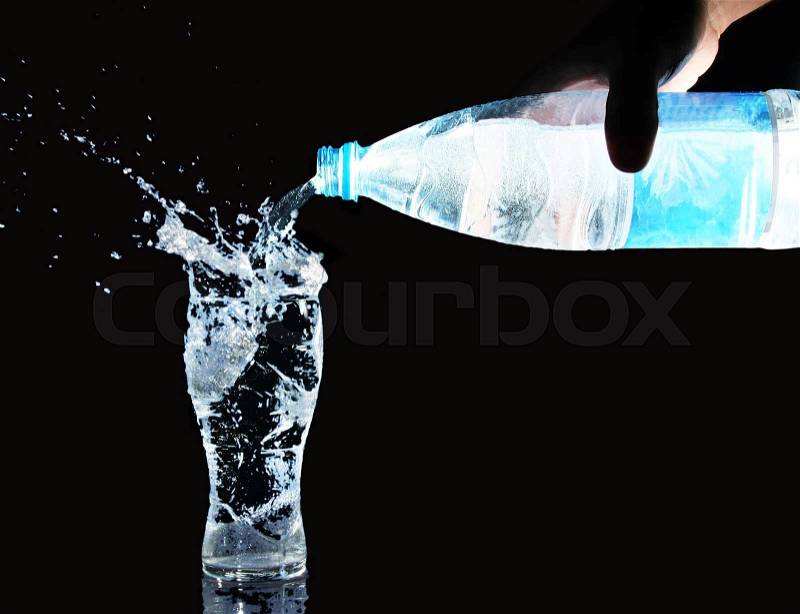 Pouring water from bottle into glass, stock photo