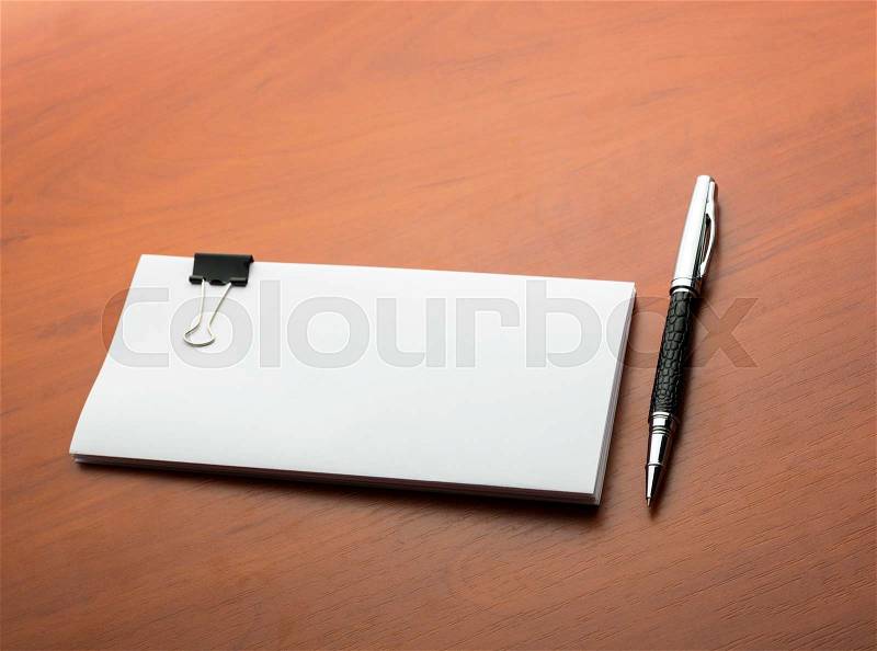 Papers and pen on a wooden desktop, stock photo