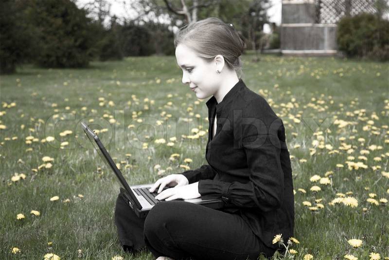 Young Woman Working On Computer In The Garden, stock photo