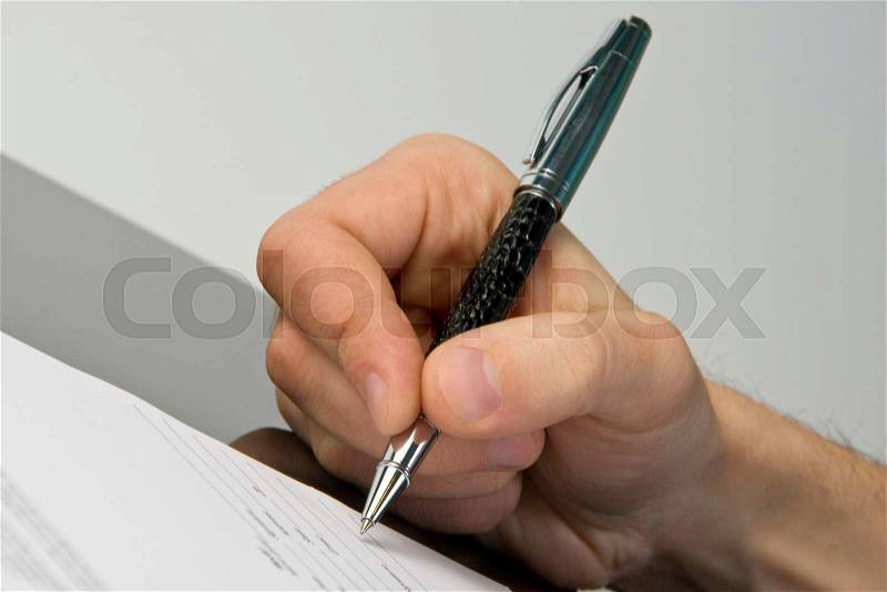 Man\'s hand signing the document, stock photo