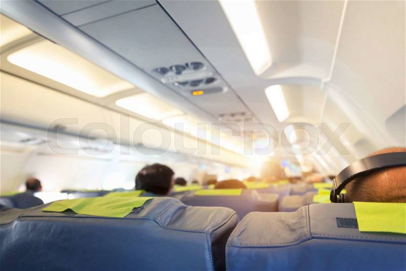 People are sitting on the seats in the plane salon, stock photo