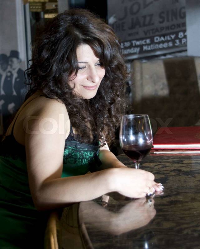 Flirting woman at bar with wineglass, stock photo