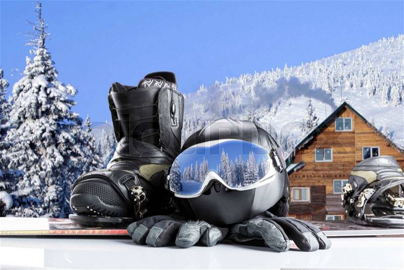 Winter sport glasses, snowboarding boot, helmet and gloves on winter mountains background, stock photo