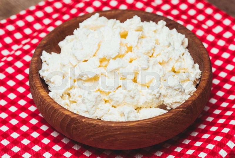 Cottage cheese or curd in a wooden bowl, stock photo