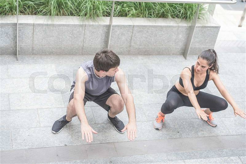 Couple of young handsome caucasian sportive man and woman doing squat, staring into each other\'s eyes - sportive, healthy, fitness concept, stock photo