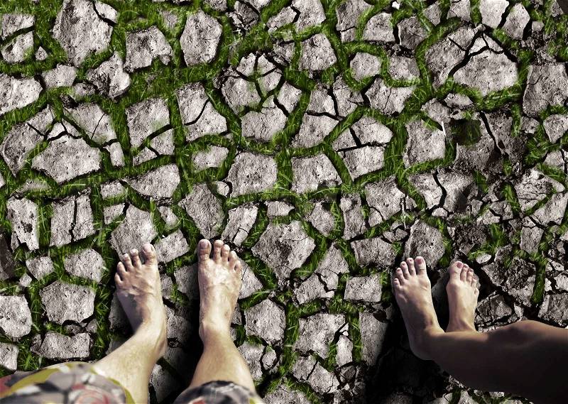 Male and female feet are standing on the dry land, stock photo