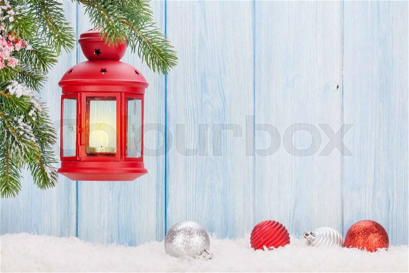 Christmas candle lantern on fir tree branch in snow. View with copy space, stock photo