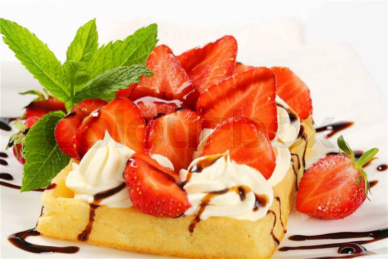 Belgian waffle with whipped cream and fresh strawberries, stock photo