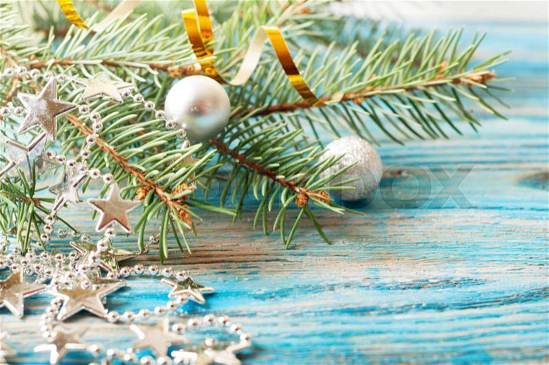 Silver Christmas decorations and fir branch on a blue wooden background, stock photo