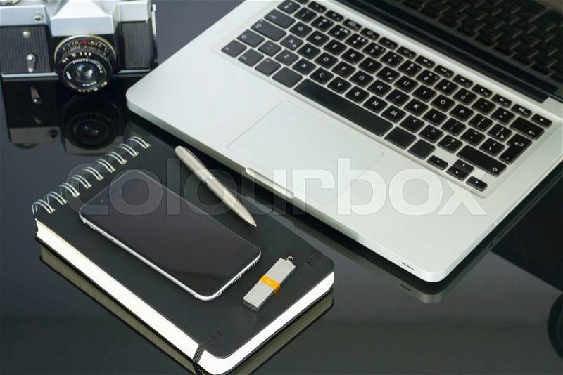 Office black glass desk table with computer, phone and supplies, stock photo