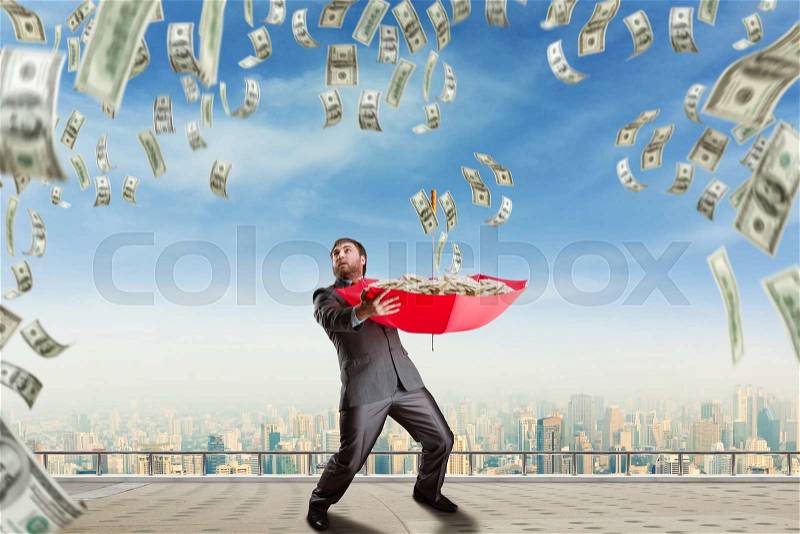 Businessman with umbrella full of money and money are falling, stock photo