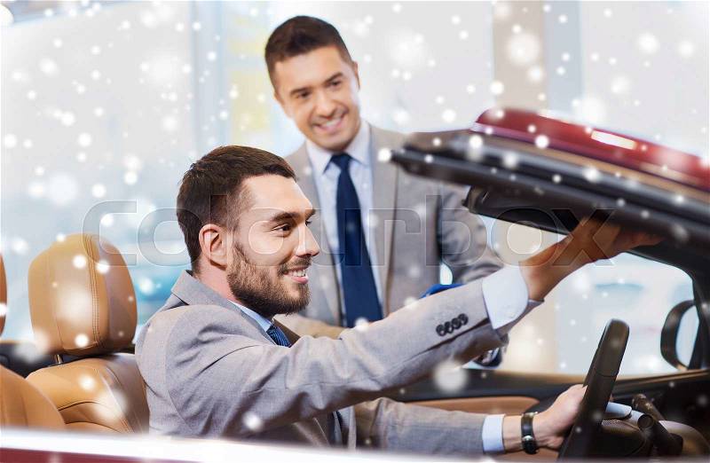Auto business, car sale, consumerism and people concept - happy man with car dealer in auto show or salon over snow effect, stock photo