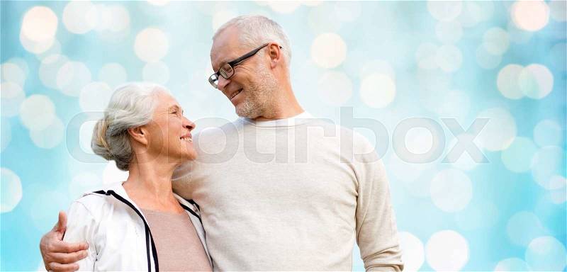 Family, old age, love and people concept - happy senior couple over blue holidays lights background, stock photo