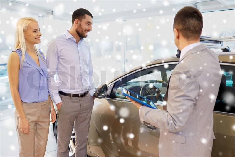 Auto business, car sale, technology and people concept - happy couple with car dealer in auto show or salon over snow effect, stock photo