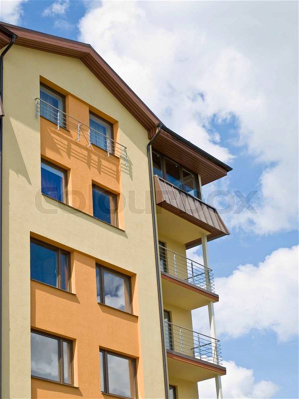Flat building against the blue sky with clouds, stock photo