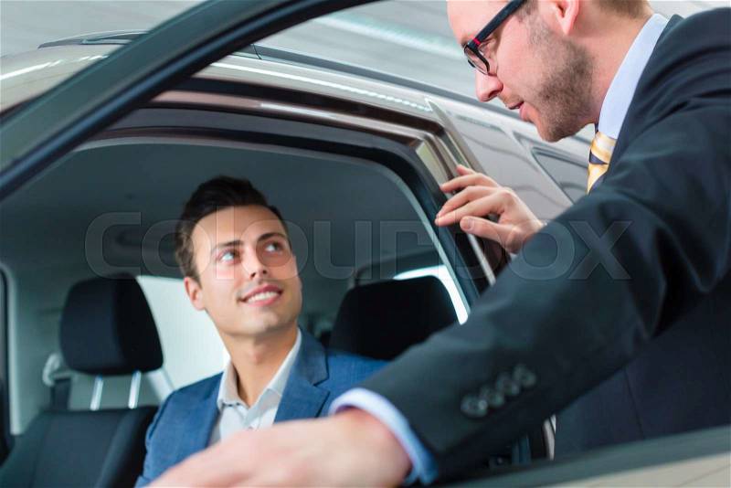 Customer buying new car in auto dealership , stock photo